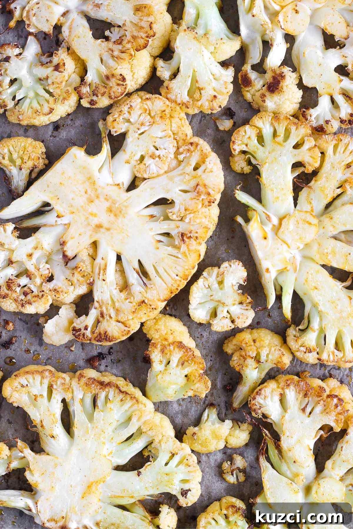 Roasted cauliflower steaks on a baking sheet.