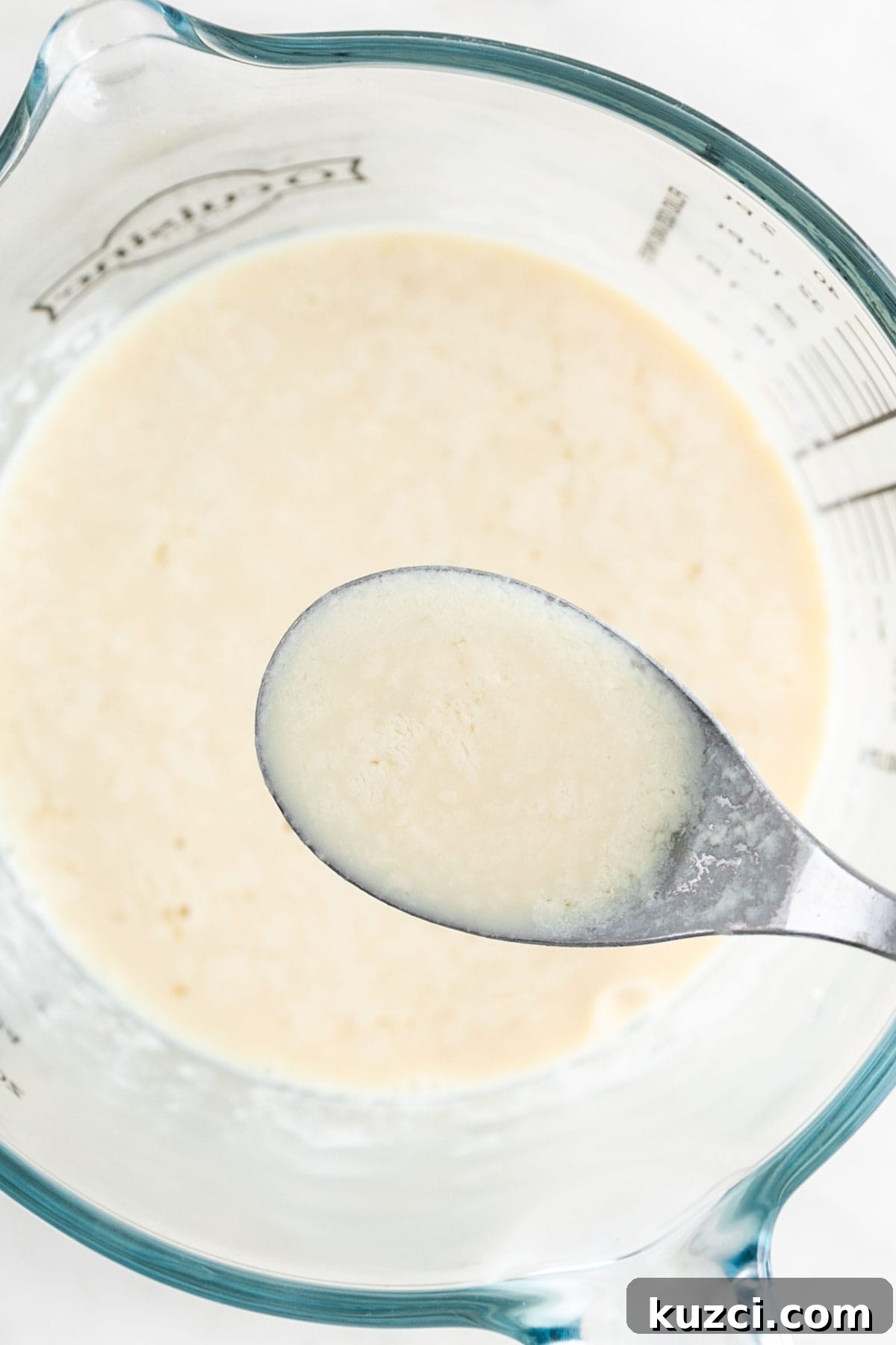 Vegan buttermilk in measuring cup with spoon.