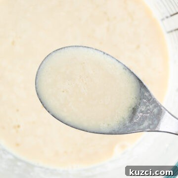 Measuring cup and spoon with vegan buttermilk.