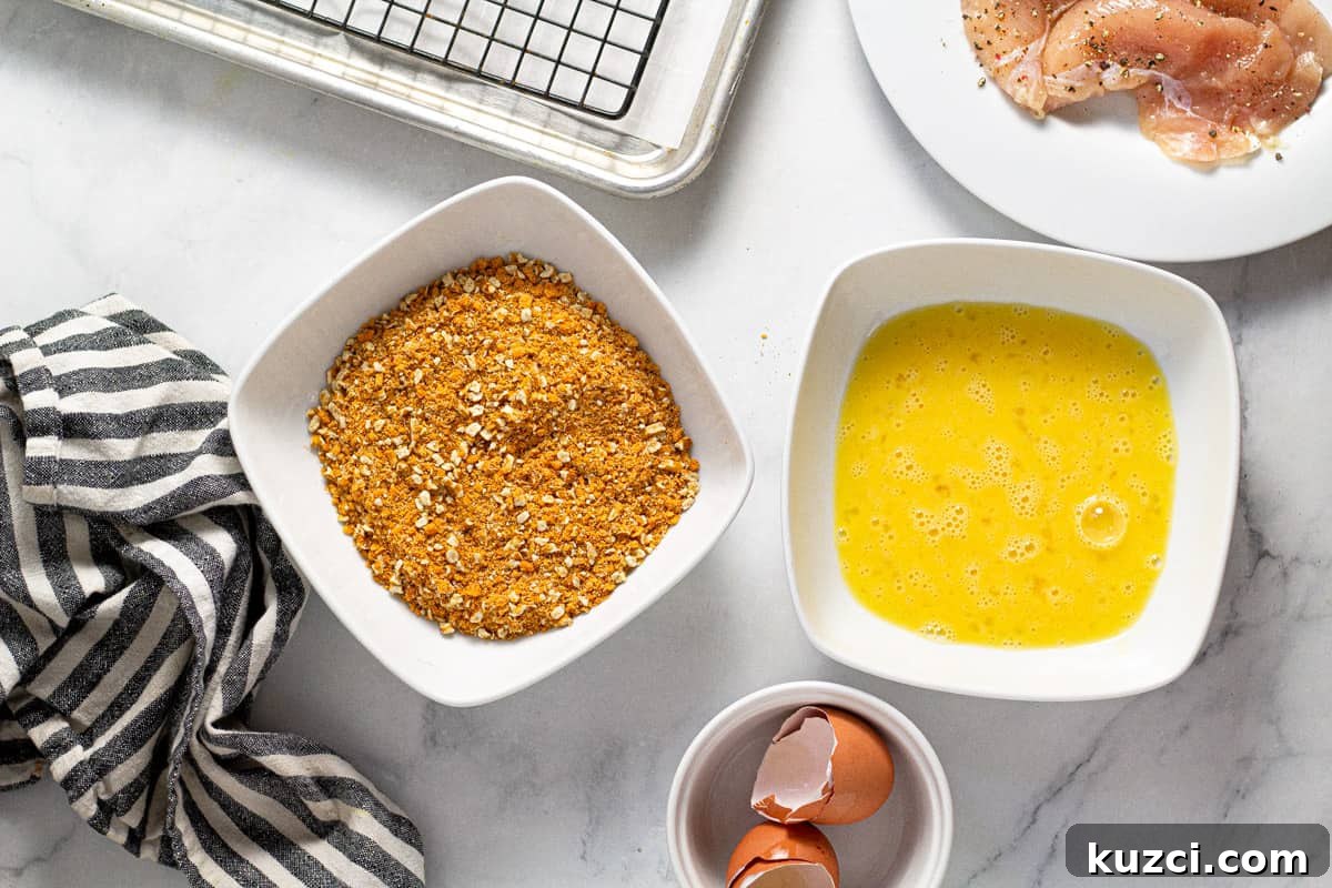 Crispy Oven Fried Chicken Tenders 6 Overhead shot of two bowls on filled with breading mixture and one filled with beaten eggs