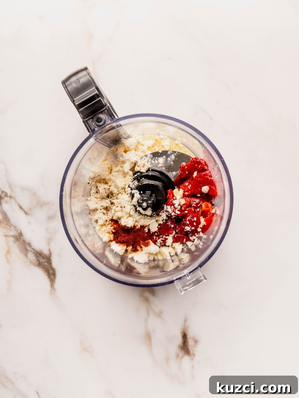 Small food processor with feta, roasted red peppers, garlic, black pepper, olive oil and smoked paprika.