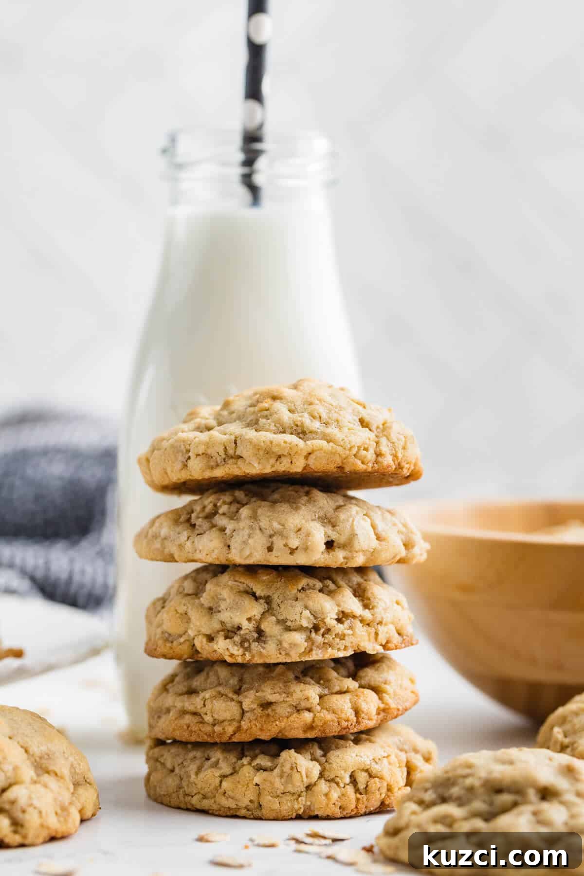 a stack of oatmeal cookies in front of a glass of milk. 