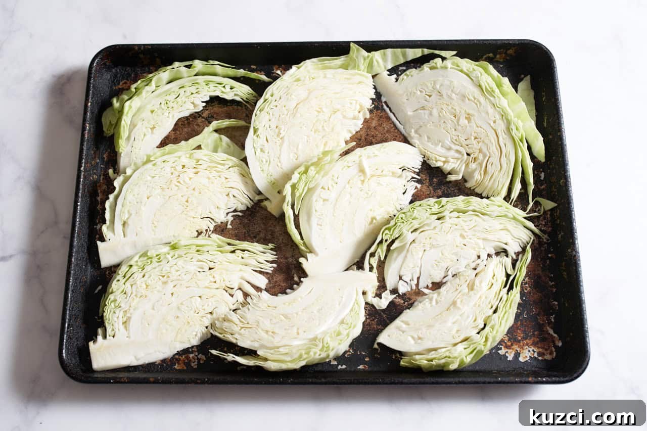 Charred Sheet Pan Cabbage with Tahini Sauce 4 Cabbage wedges on a sheet pan.