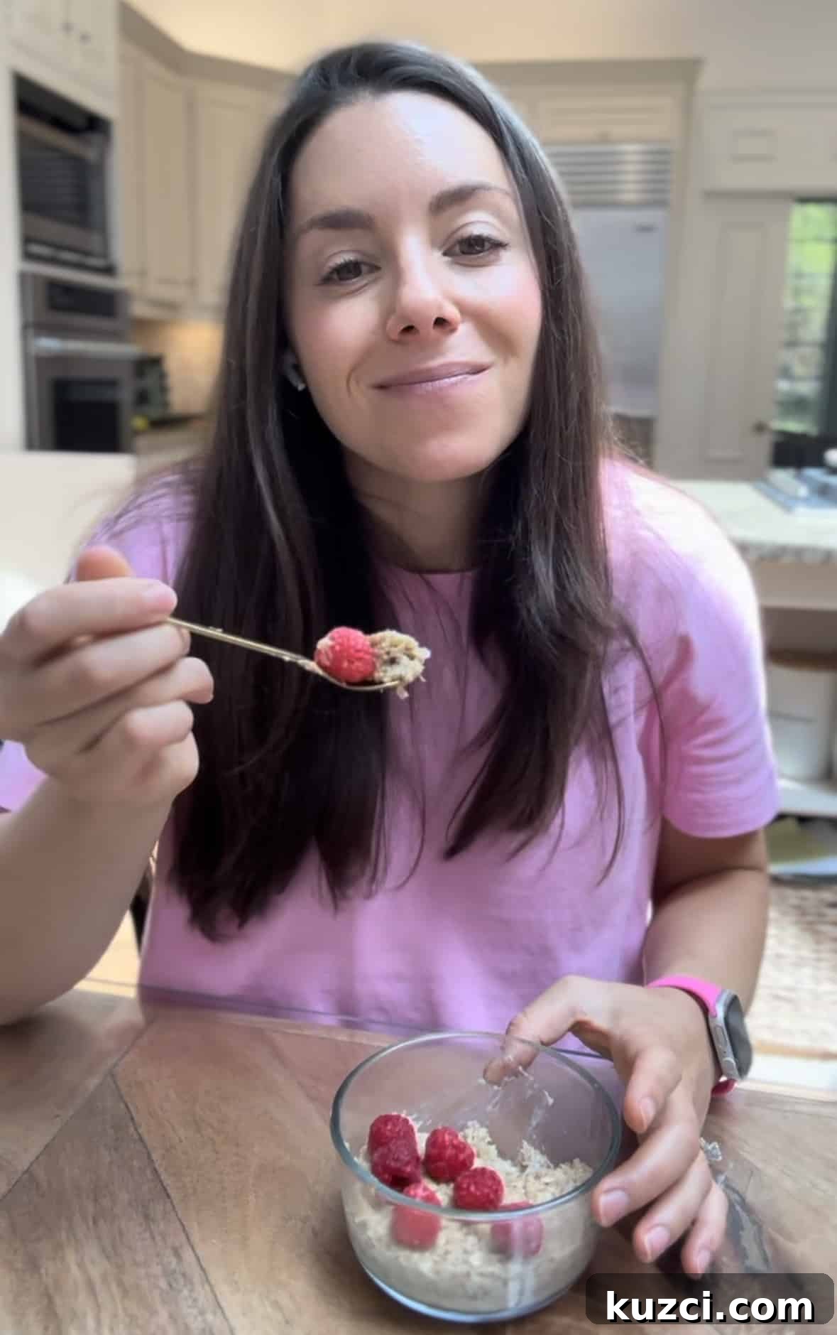 18 Toddler Breakfast Ideas from a Registered Dietitian 6 Kacie Barnes of Mama Knows Nutrition eating a bowl of microwave baked oatmeal topped with nut butter and raspberries