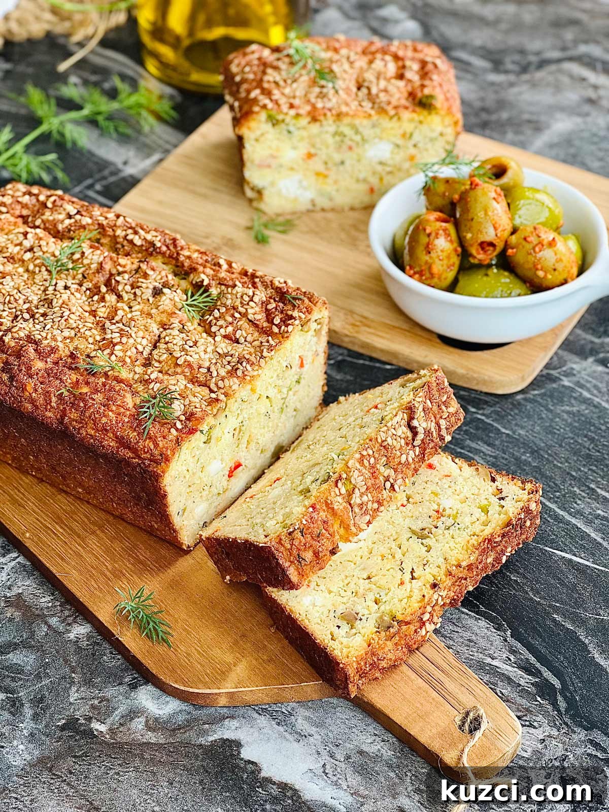 Flourless Lentil Bread Recipe 2 Sliced lentil bread on a wooden chopping board and further away another piece of lentil bread and olives on a wooden board.