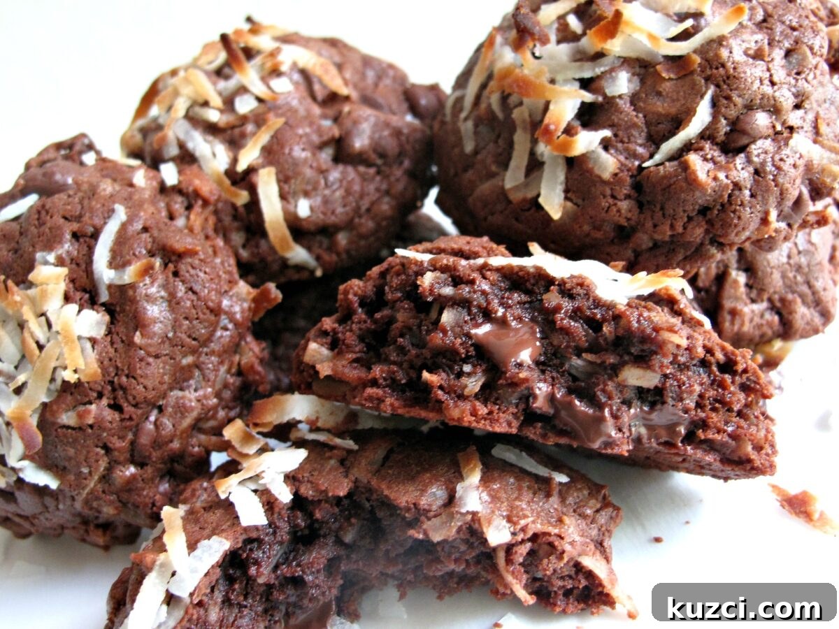 Chocolate Coconut Bliss Cookies - chewy fudgy chocolate cookie with coconut inside and out. Inside of chocolate coconut cookie showing melted chocolate chips, dark chocolate dough, and shredded coconut.