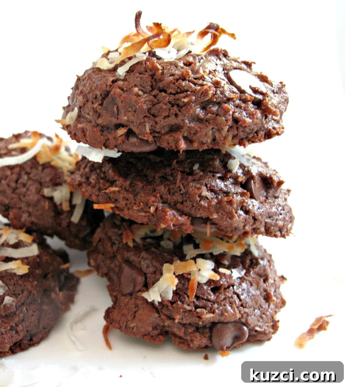 Chocolate Coconut Bliss Cookies - chewy fudgy chocolate cookie with coconut inside and out. Stack of three cookies.