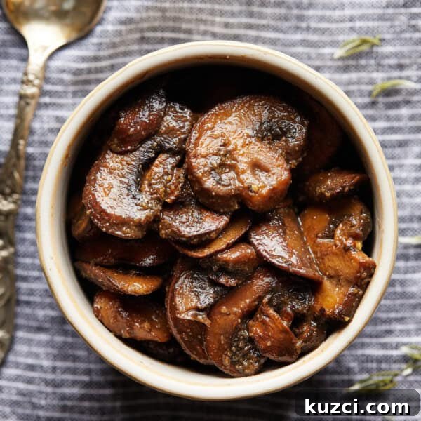 Zucchini Risotto Recipe: Creamy Stovetop Method 9 Overhead photo of browned sliced mushrooms in a small bowl on a striped cloth.