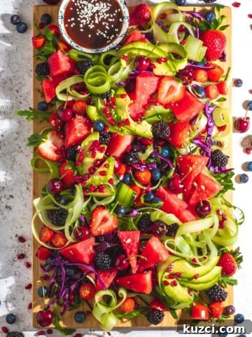Rainbow salad on a wooden board and a white background.