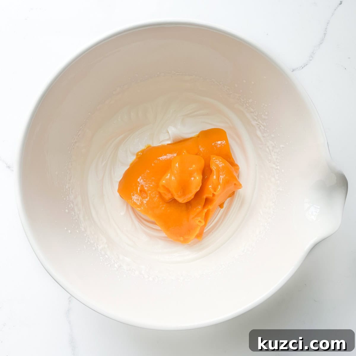 Creamy Mango Mousse Recipe 7 Adding the mango puree to the whipped double cream for the mango mousse.