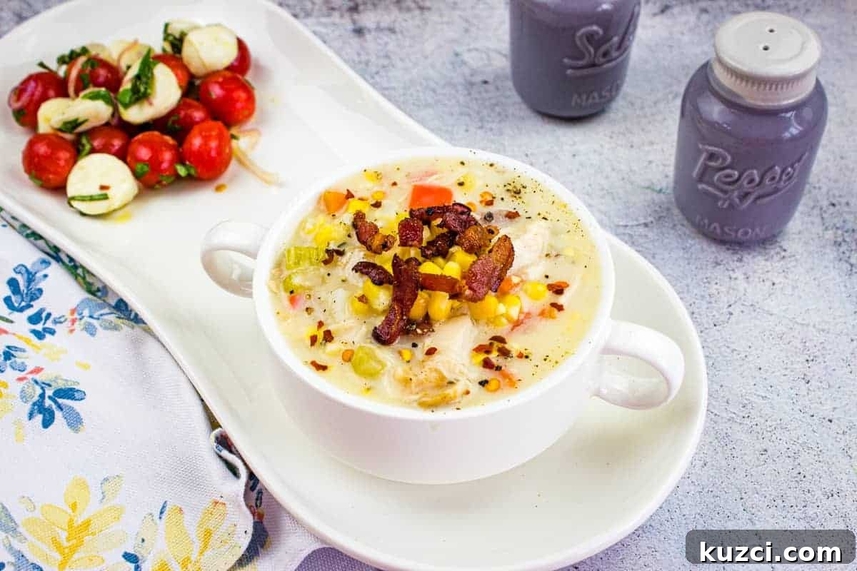 33 Fall Dinner Recipes Packed With Comfort Food Favorites 22 Chicken & Corn Chowder in a black bowl, topped with bacon, scallions, and red pepper flakes.