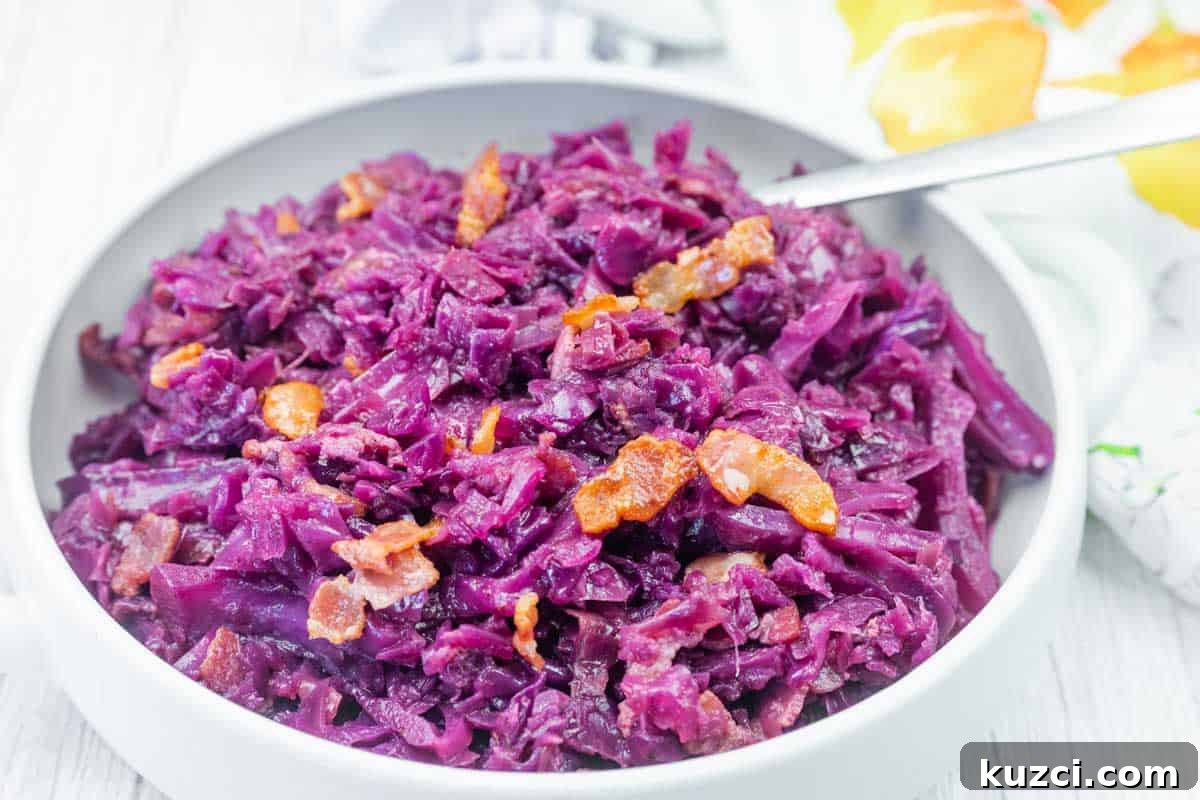 33 Fall Dinner Recipes Packed With Comfort Food Favorites 4 A bowl of cooked red cabbage mixed with small pieces of bacon, served with a spoon.