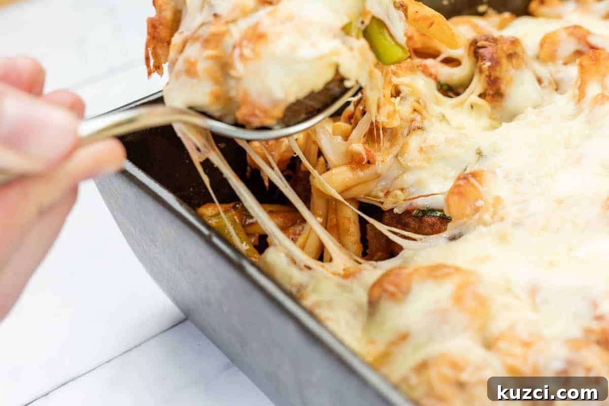 33 Fall Dinner Recipes Packed With Comfort Food Favorites 5 A hand uses a spoon to serve Easy Cheesy Meatball Casserole from a rectangular baking dish, with melted cheese stretching from the dish.