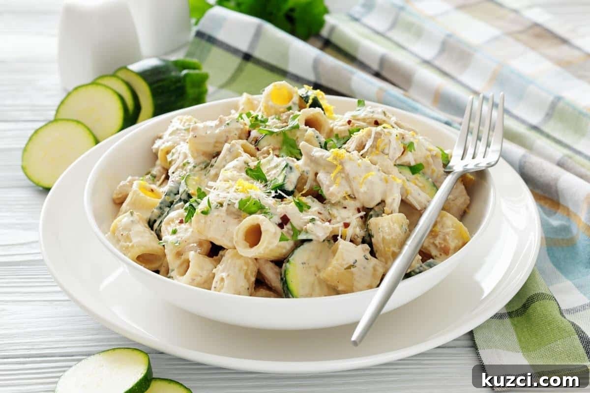 33 Fall Dinner Recipes Packed With Comfort Food Favorites 7 A bowl of Zucchini & Chicken Alfredo, served with a fork on a white plate.