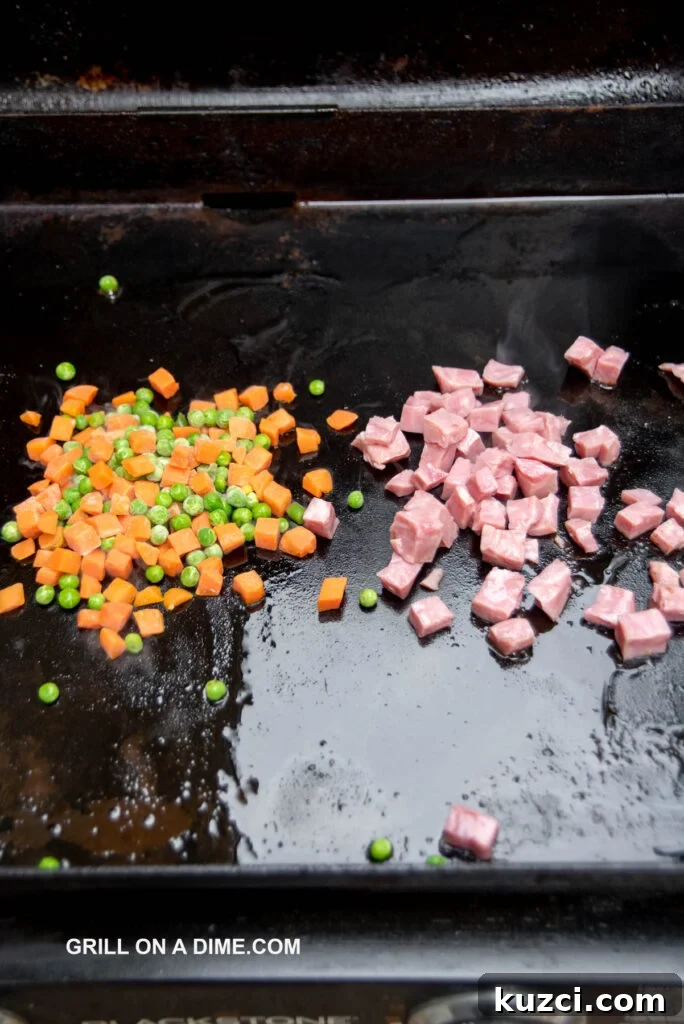 Savory Ham Fried Rice with Eggs and Vegetables 5 Cooking the peas, carrots and ham on the griddle