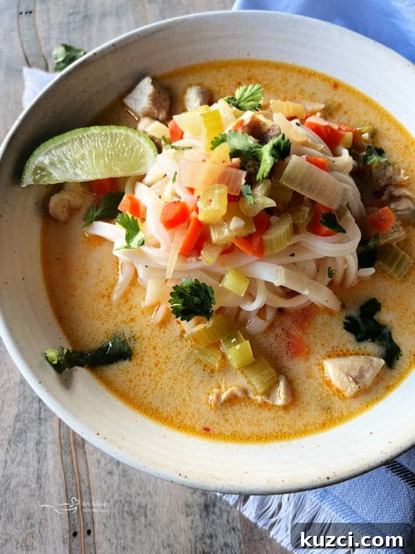 Thai Chicken Noodle Soup white bowl filled with Thai chicken noodle soup and noodles