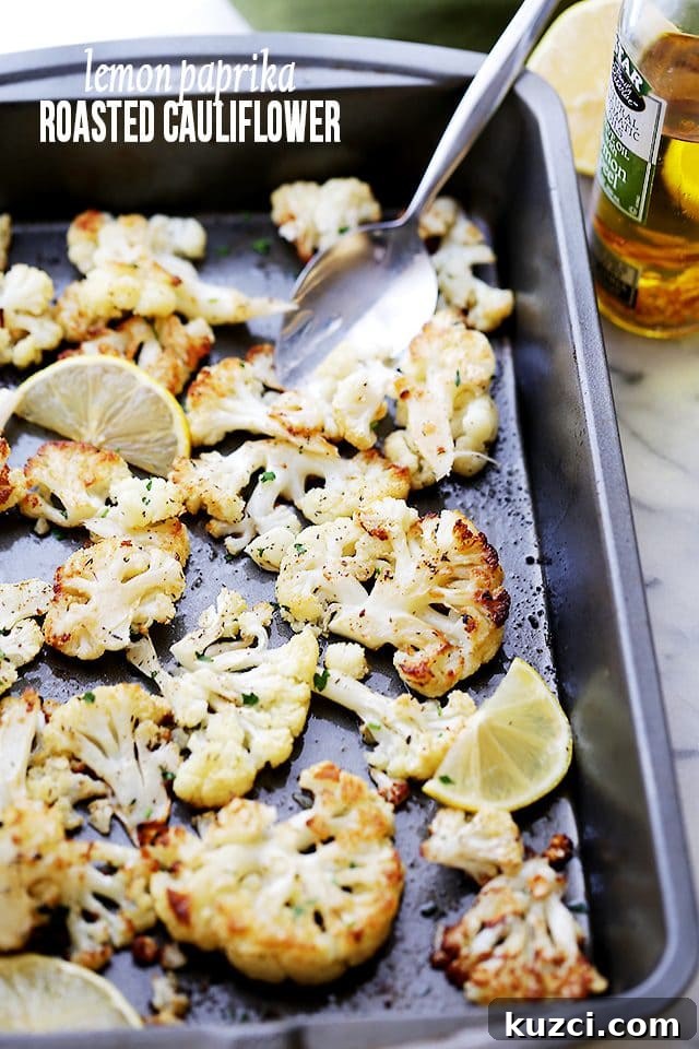 Make crispy roasted cauliflower tossed in olive oil and seasoned with lemon zest, paprika, and thyme. An easy, flavorful vegetable side dish! Overhead view of roasted cauliflower seasoned with lemon, paprika, and thyme on a baking sheet.