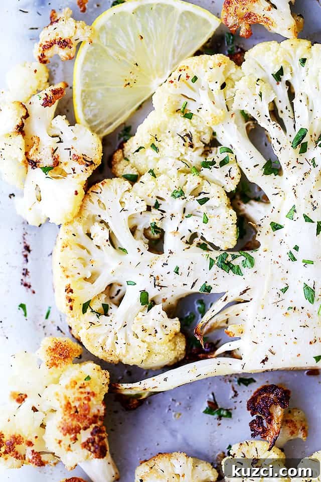 Make crispy roasted cauliflower tossed in olive oil and seasoned with lemon zest, paprika, and thyme. An easy, flavorful vegetable side dish! Overhead view of roasted cauliflower seasoned with lemon, paprika, and thyme on a baking sheet.