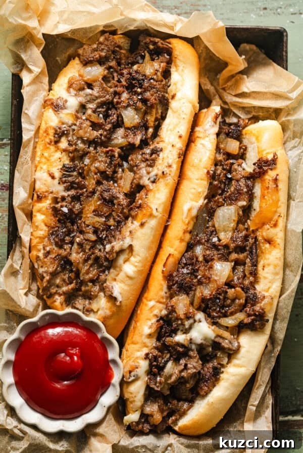 philly cheesesteaks in a basket with parchment paper and a small bowl of ketchup.