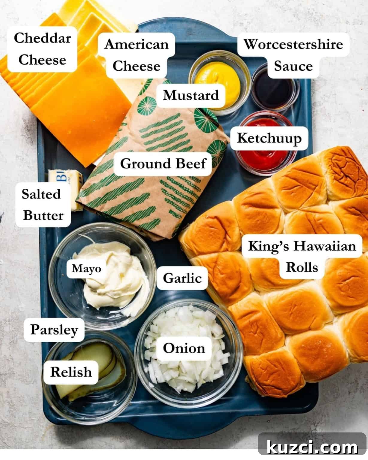 cheeseburger slider ingredients - ground beef, butter, parsley, garlic, ketchup, mustard, relish, hawaiian rolls, american cheese, cheddar cheese, mayo, onion, garlic powder, onion powder, and worcestershire sauce.