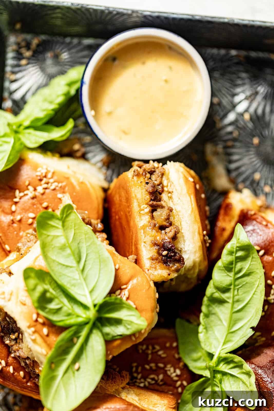 cheeseburger slider on a silver plate with burger sauce.