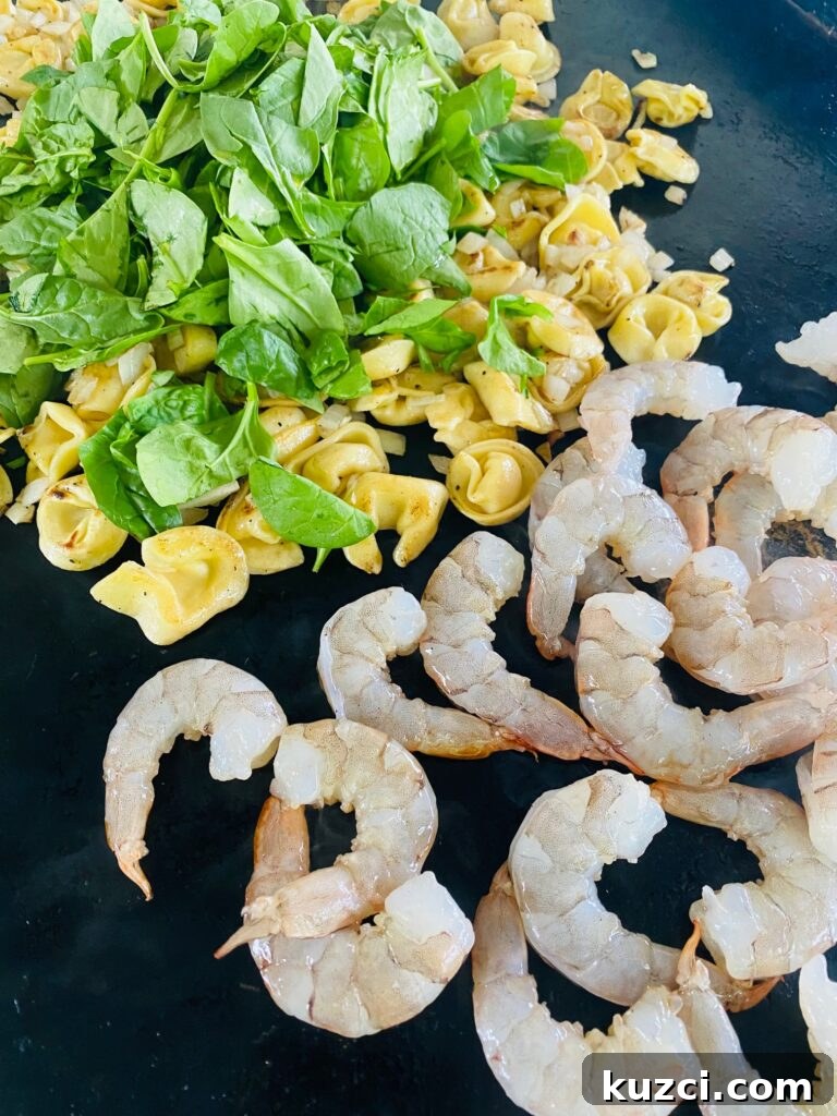 Blackstone Shrimp Tortellini with Red Pepper Sauce 7 adding shrimp and spinach