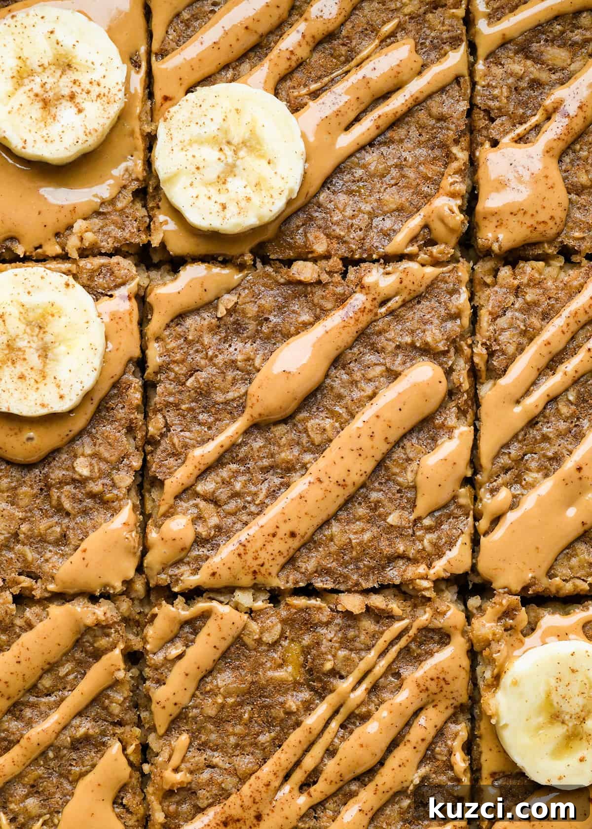 Peanut Butter Banana Baked Oatmeal Recipe 8 close up photo of Peanut Butter Banana Baked Oatmeal cut into 9 squares, drizzled with peanut butter, topped with sliced bananas and cinnamon