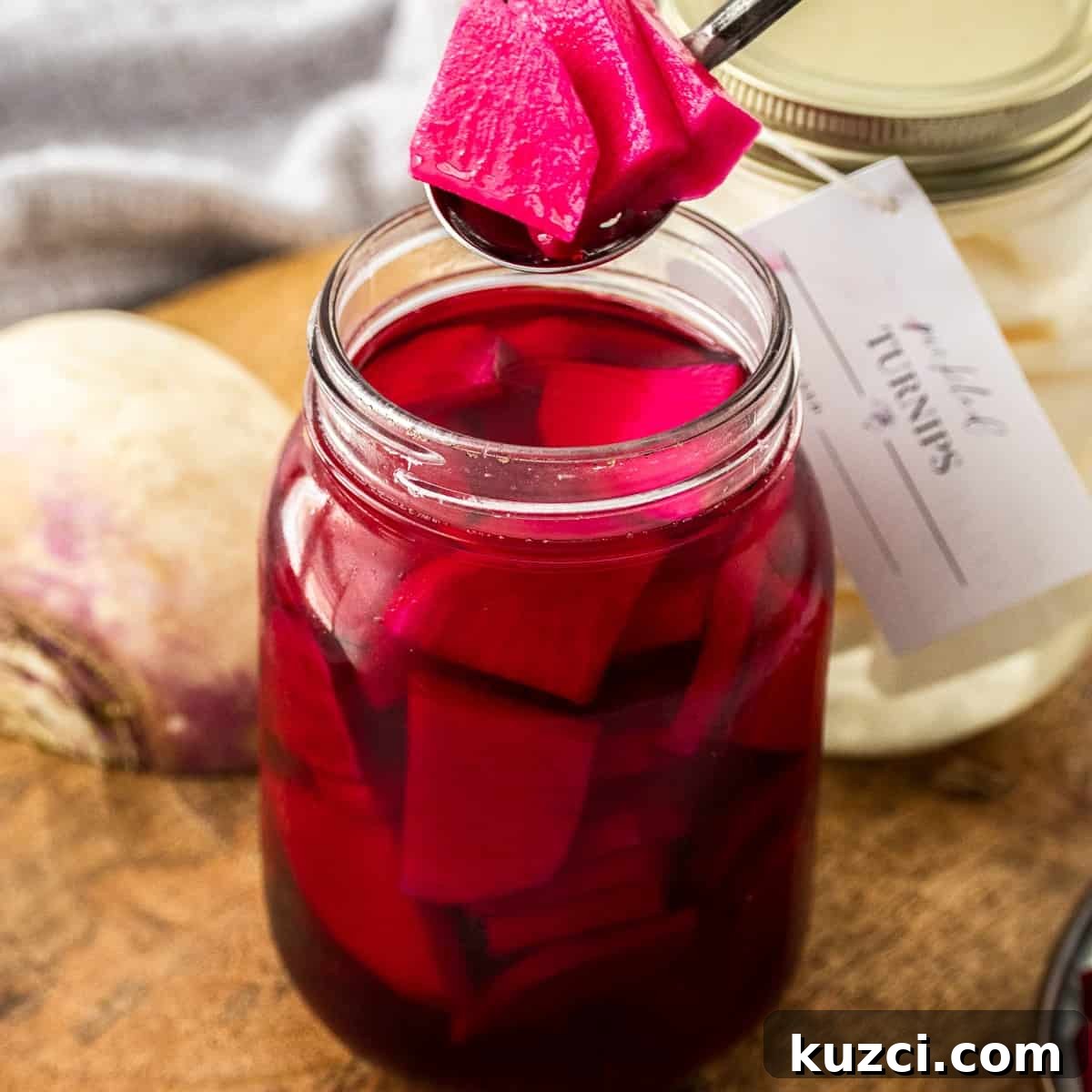 Spoon lifting some Beetroot Pickled Turnips out of the jar.