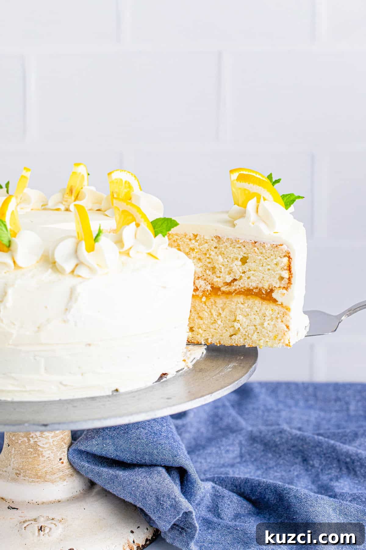 Zesty Lemon Layer Cake with Silky Buttercream 6 Cake server pulling out a slice of cake