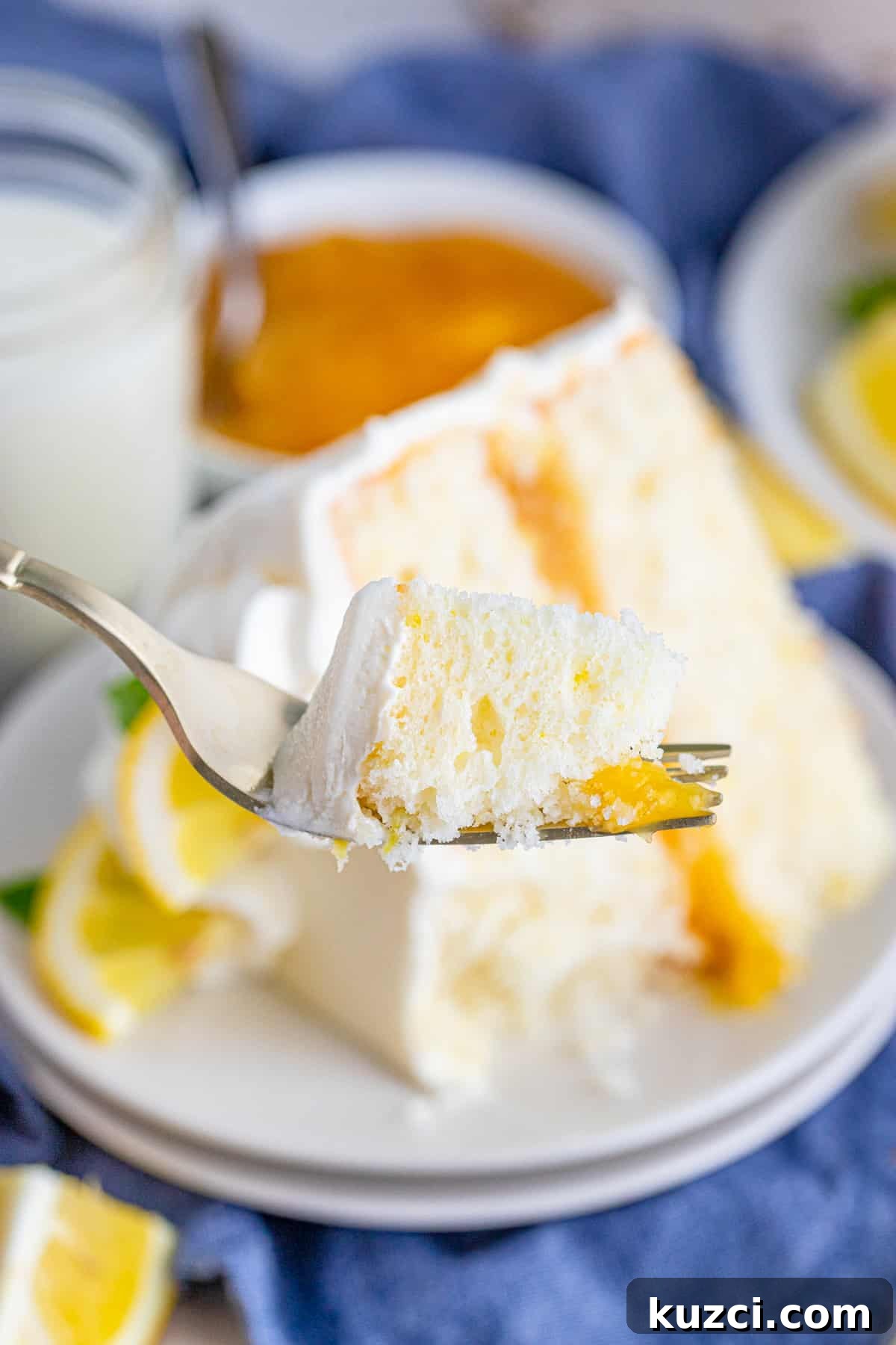 Zesty Lemon Layer Cake with Silky Buttercream 8 Bite of cake on fork being held up
