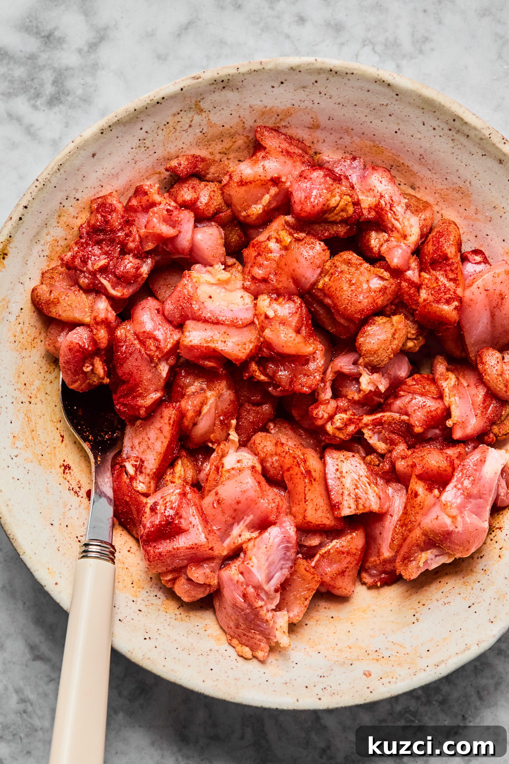 Bite-sized pieces of raw chicken thighs are tossed in smoked paprika, cumin and salt