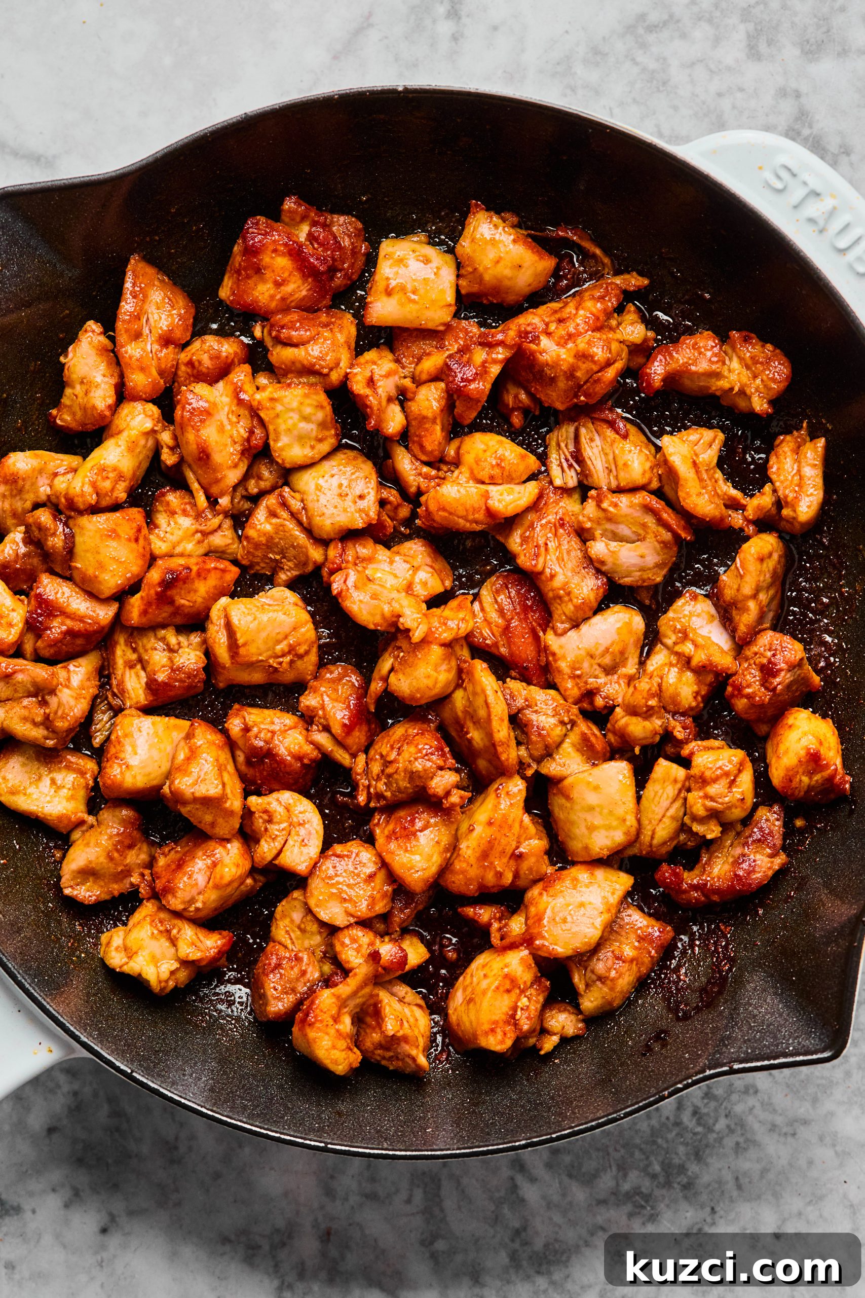 A large skillet filled with perfectly seared chicken bites
