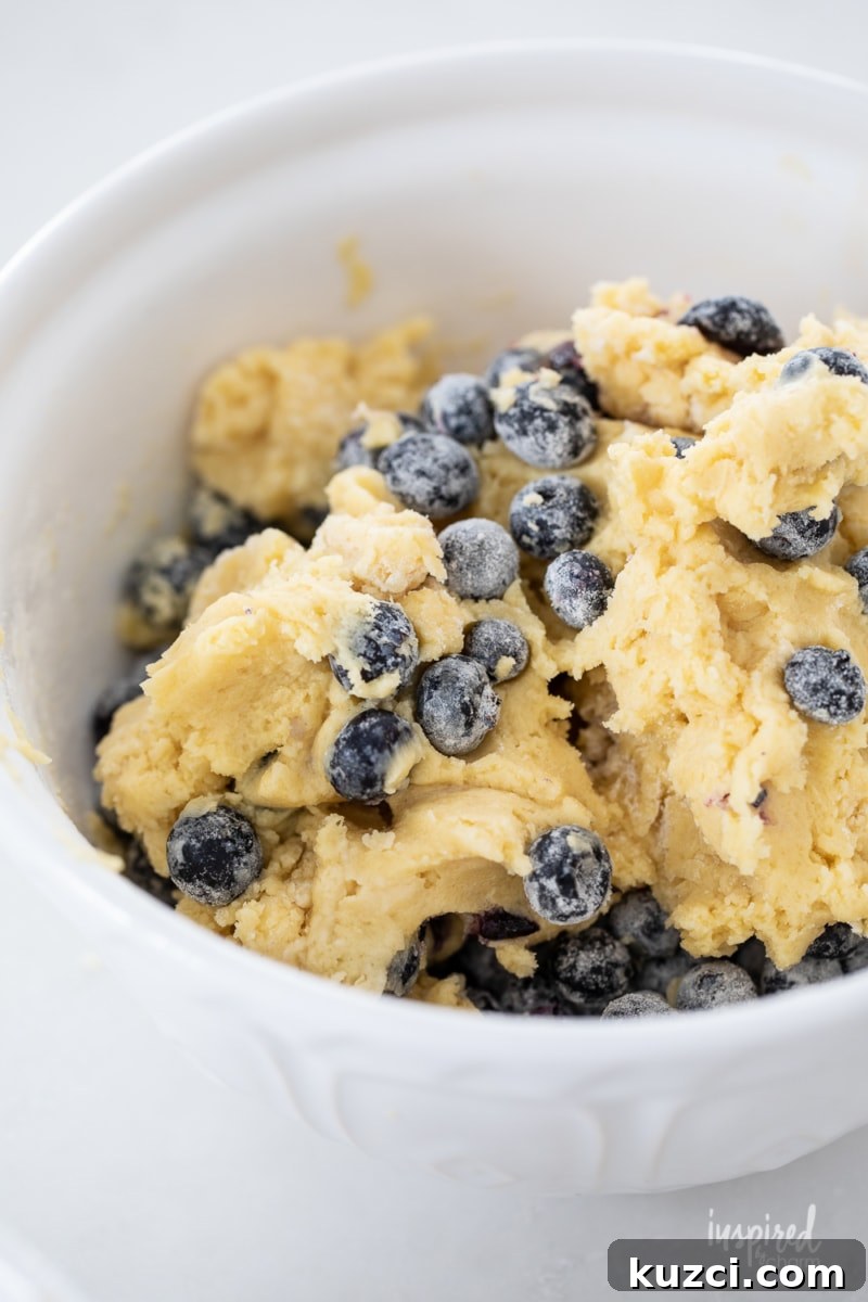 Moist Blueberry Cake Recipe with Lemon Glaze 6 adding flour coated berries to cake mixture