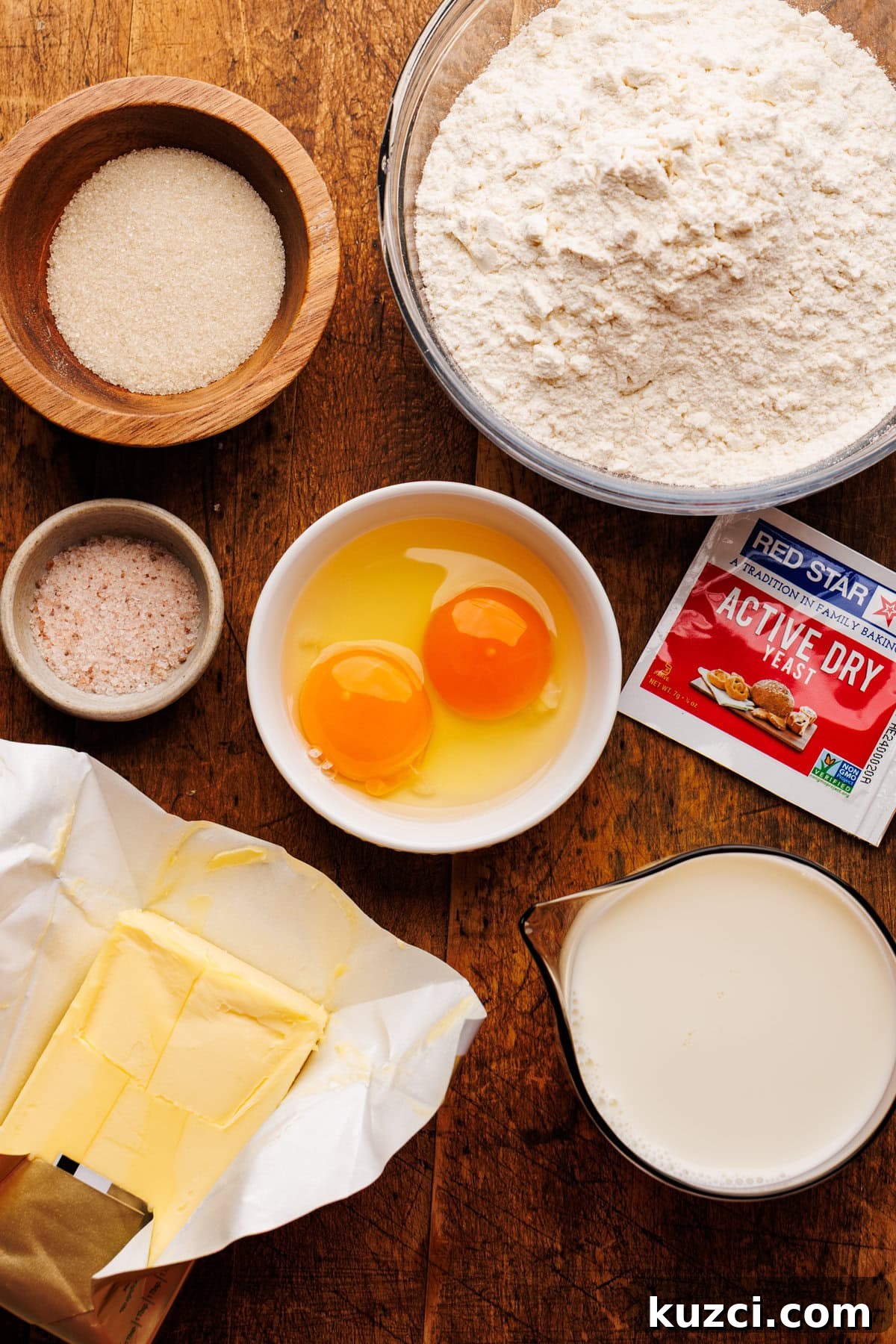 Soft, Buttery Homemade Dinner Rolls Recipe 3 Ingredients for dinner rolls arranged on a wooden board.
