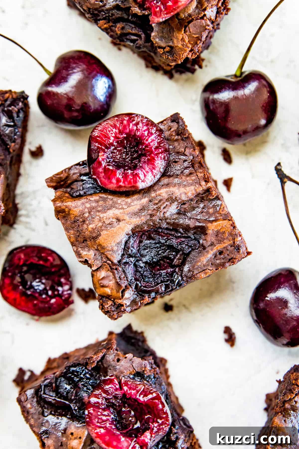 Fudgy Cherry Brownies with Dark Chocolate 2 Cut up cherry brownies with fresh cherries on top surrounded by fresh cherries.