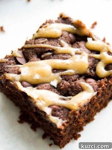 One large piece of a dairy free brownie with caramel drizzled on it.
