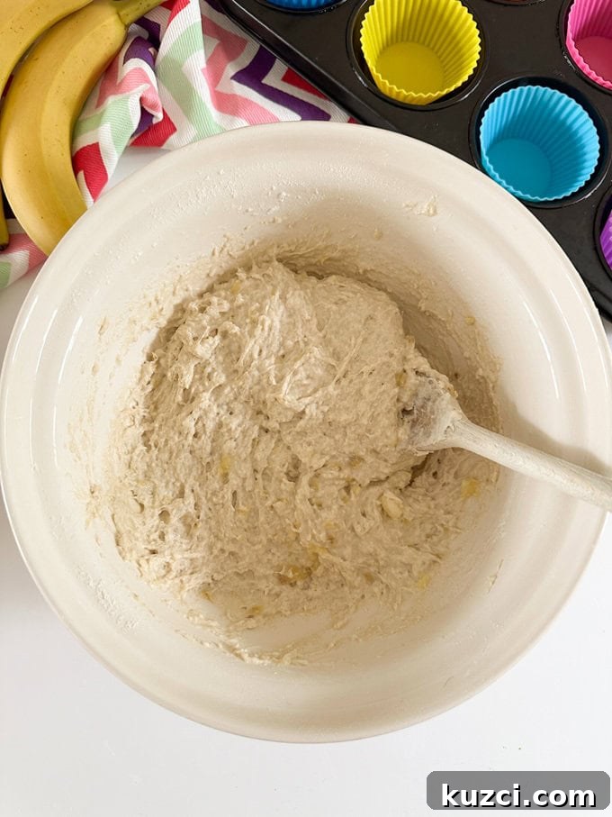 Ingredients for the muffins being added to a large mixing bowl.