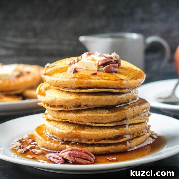 Stack of fluffy pancakes drizzled with maple syrup.