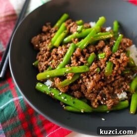 Ground Beef Stir Fry Recipe with Vegetables 5 Ground beef stir fry in a bowl on top of rice with chopsticks on the side.