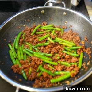 Ground Beef Stir Fry Recipe with Vegetables 7 Ground beef and green beans cooking in a wok.