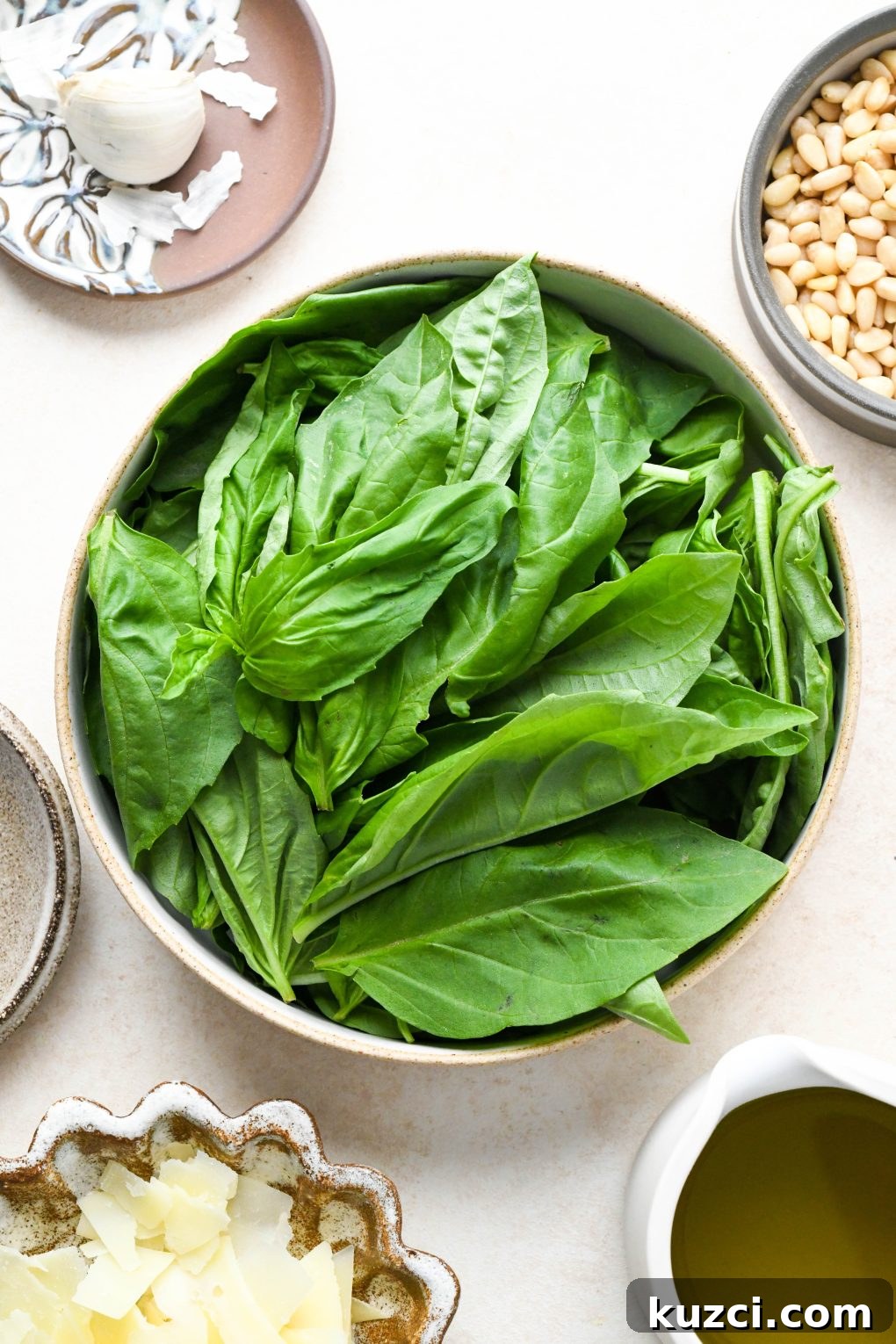 Homemade Basil Pesto - Vegan-Friendly Recipe 4 Ingredients for homemade basil pesto in various ceramics on a cream colored background.