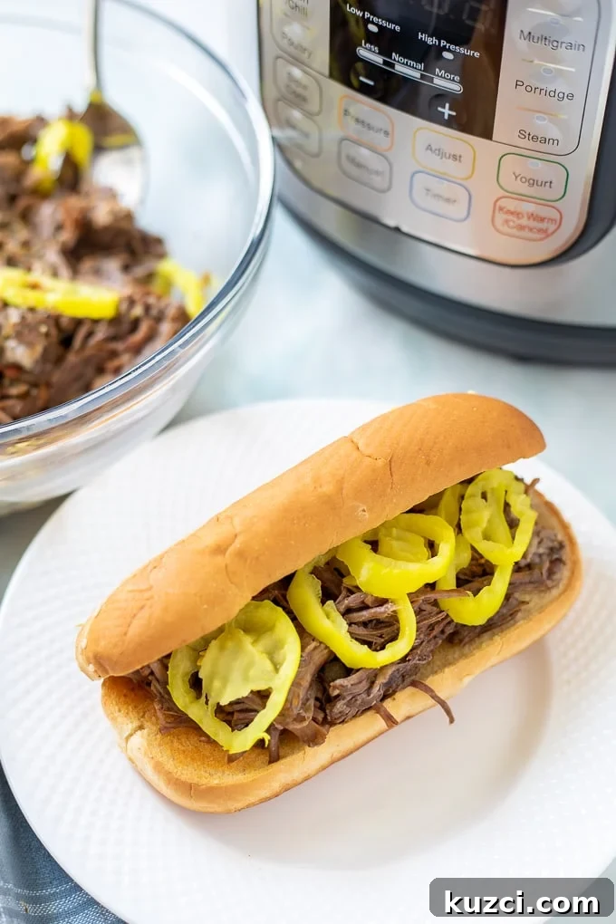 Bowl of Shredded Instant Pot Italian Beef next to Italian Beef Sandwich next to Instant Pot.