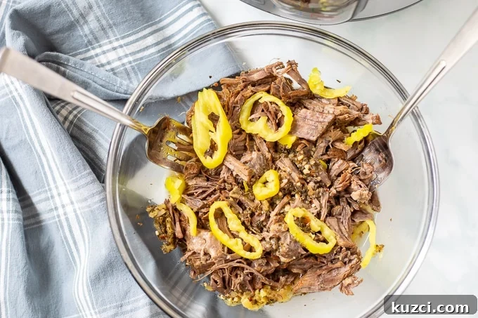 Bowl of Shredded Italian Beef topped with Pepperoncini Peppers.