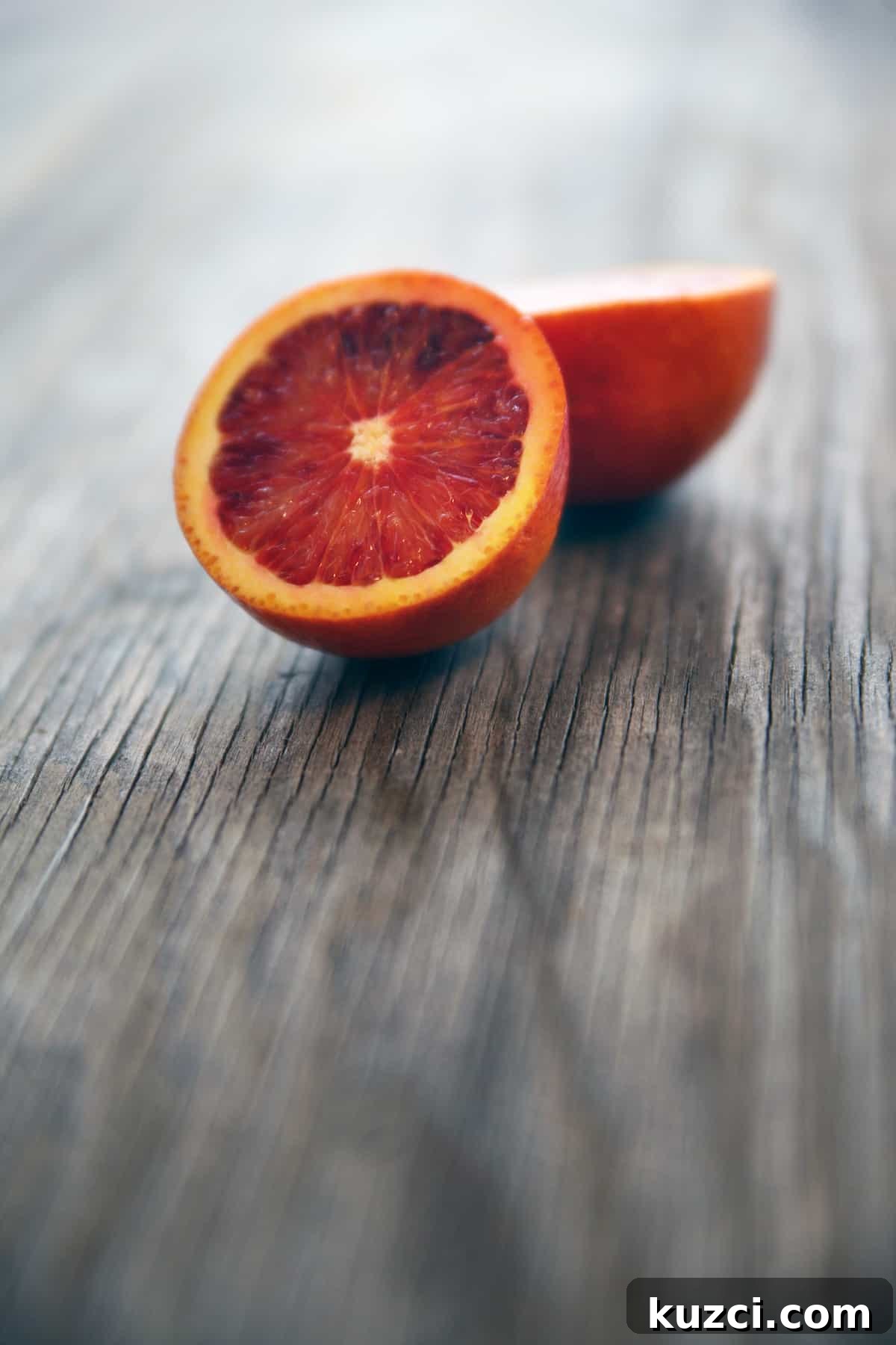 Witches' Brew Sangria: Spooky Halloween Cocktail 4 Halved blood orange on a rustic wooden table.