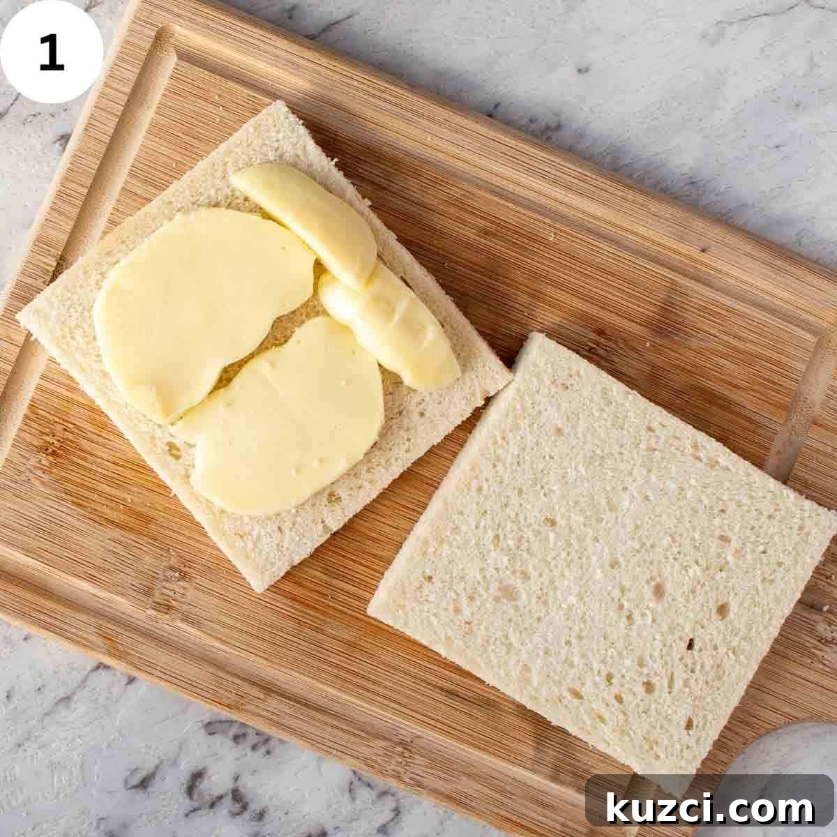 Two slices of crustless white bread, one topped with mozzarella slices.