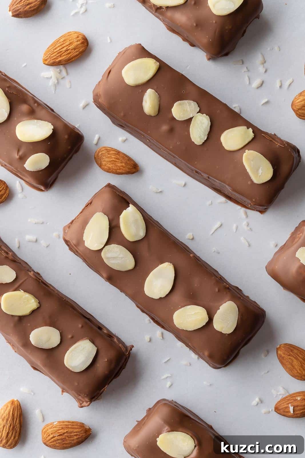 No-Bake Coconut Chocolate Bar Recipe 2 Candy bars topped with almonds on a tray.
