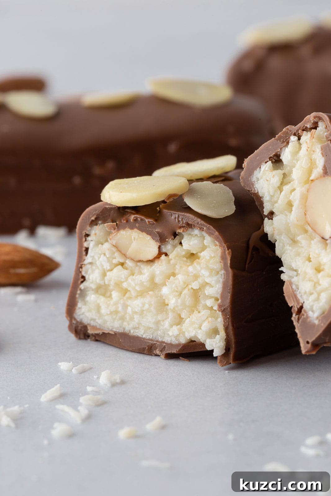 No-Bake Coconut Chocolate Bar Recipe 11 Coconut almond filling is visible inside a cut candy bar.