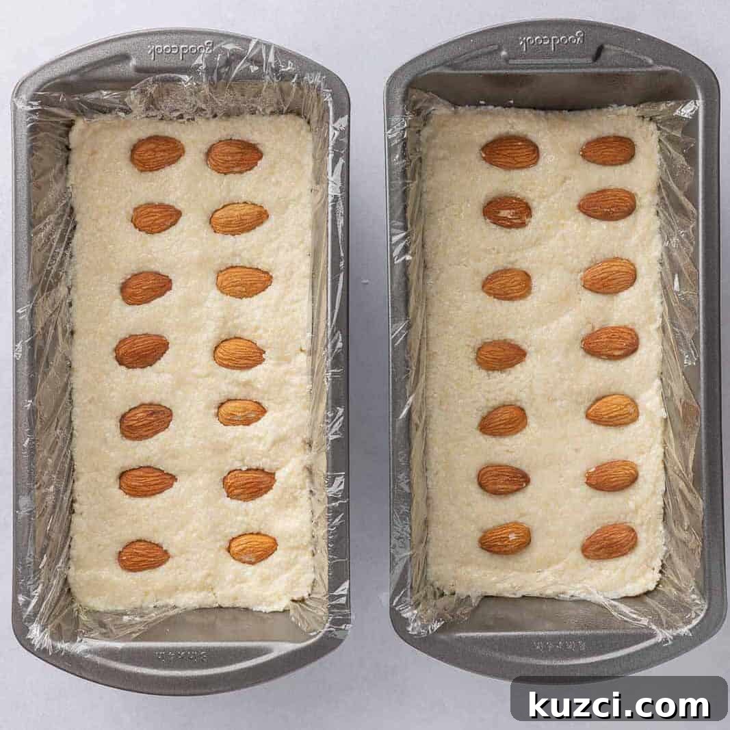 No-Bake Coconut Chocolate Bar Recipe 5 Coconut and almond candy bar filling is pressed into two pans lined with plastic wrap.