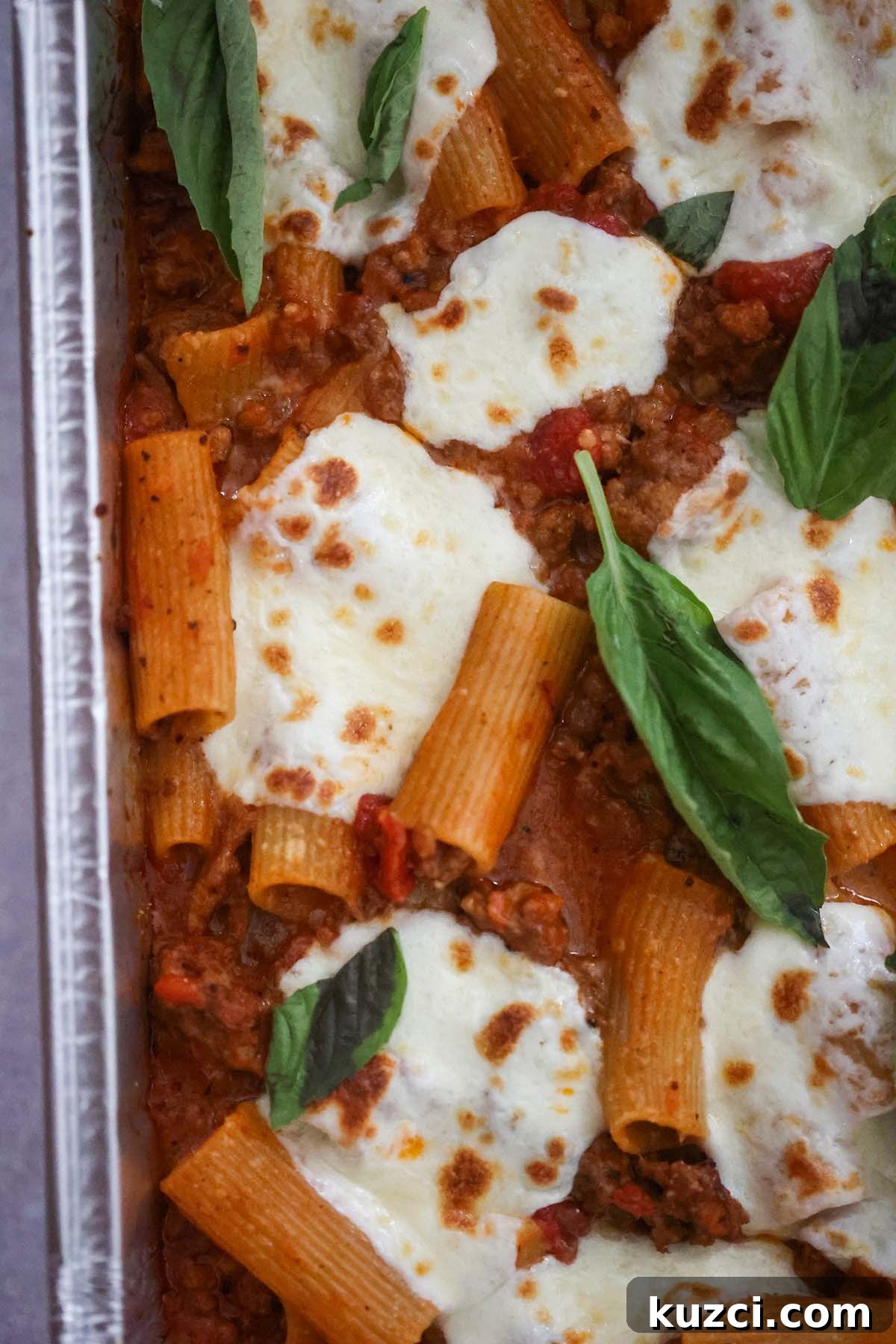 Baked rigatoni with fresh basil on top.