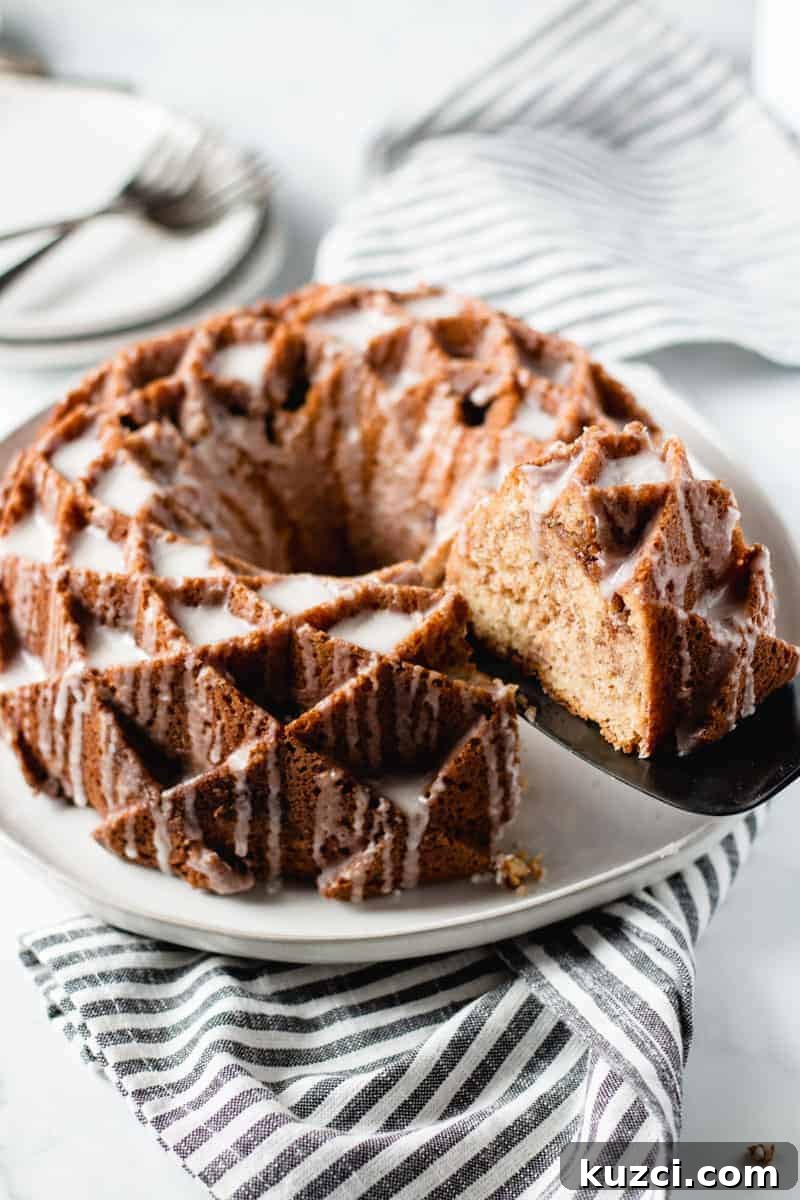 sour cream coffee cake, bundt cake on a plate, slice being removed